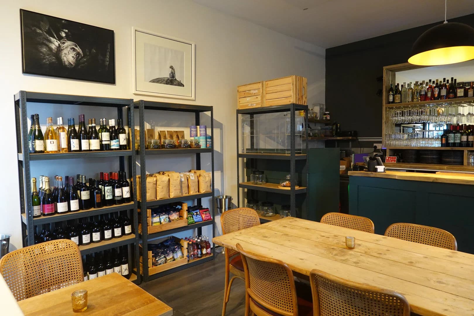 Blended cafe interior with wooden tables, wine shelves and bar area